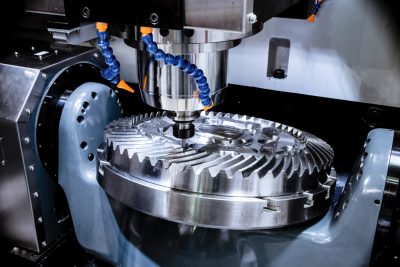 دستگاه CNC در حال کار، تحت نظارت یک CNC کار ماهر برای تولید قطعات دقیق